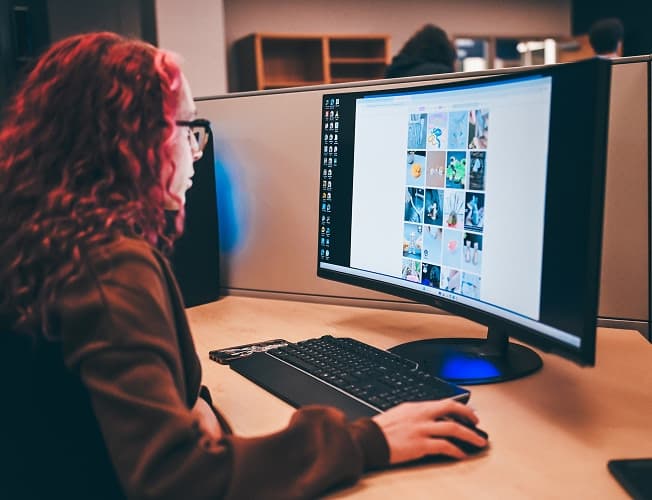 Student reviewing data visualizations on a widescreen monitor
